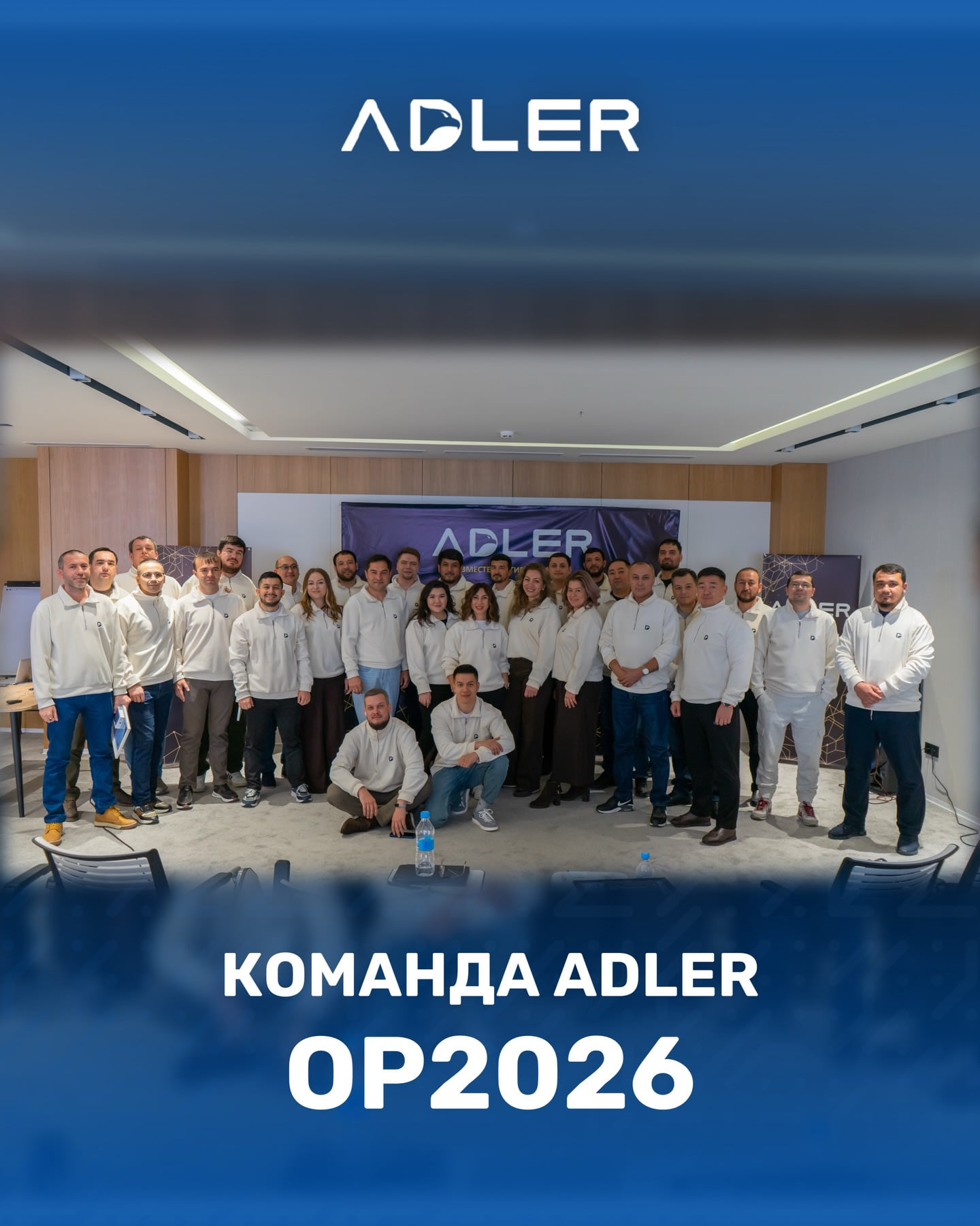 Общая фотография сотрудников в конференц-зале под экраном с логотипом ADLER, внизу кадра подпись «Команда ADLER · OP2026»